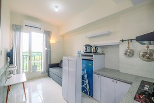 Una cocina compacta con refrigerador, cafetera y un armario azul.