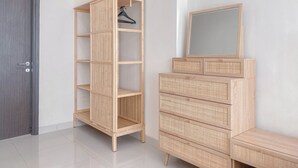 Ein Zimmer mit einem Holzschrank, einem Spiegel und einer Tür.