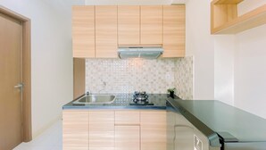Une cuisine moderne avec des meubles en bois, un évier en acier inoxydable et une cuisinière à gaz.