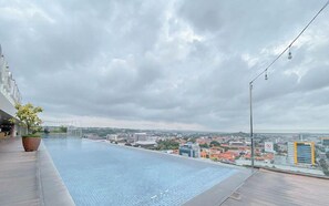 A rooftop pool with a city view, a potted plant, and a street lamp. - Good Homey Studio Apartment at Warhol (W/R) Residences (Semarang)