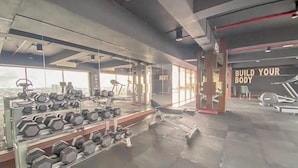 A gym with weightlifting equipment, treadmills, and a motivational sign. - Good Homey Studio Apartment at Warhol (W/R) Residences (Semarang)