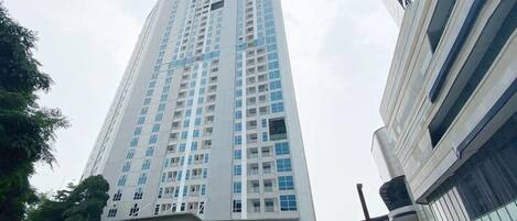 A tall, modern building with a prominent entrance and multiple floors.