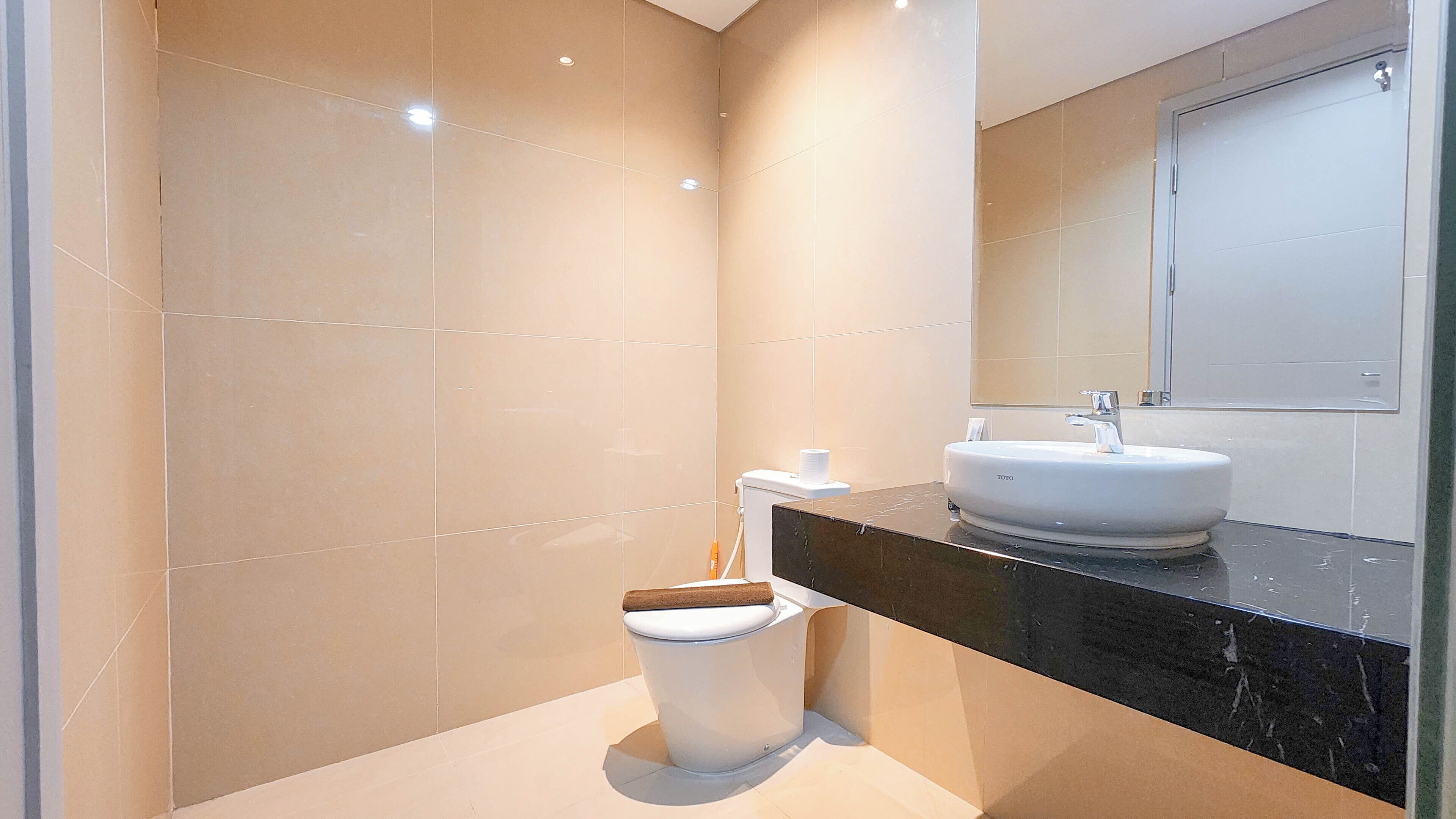 A modern bathroom with a white toilet, a sink, and a mirror.