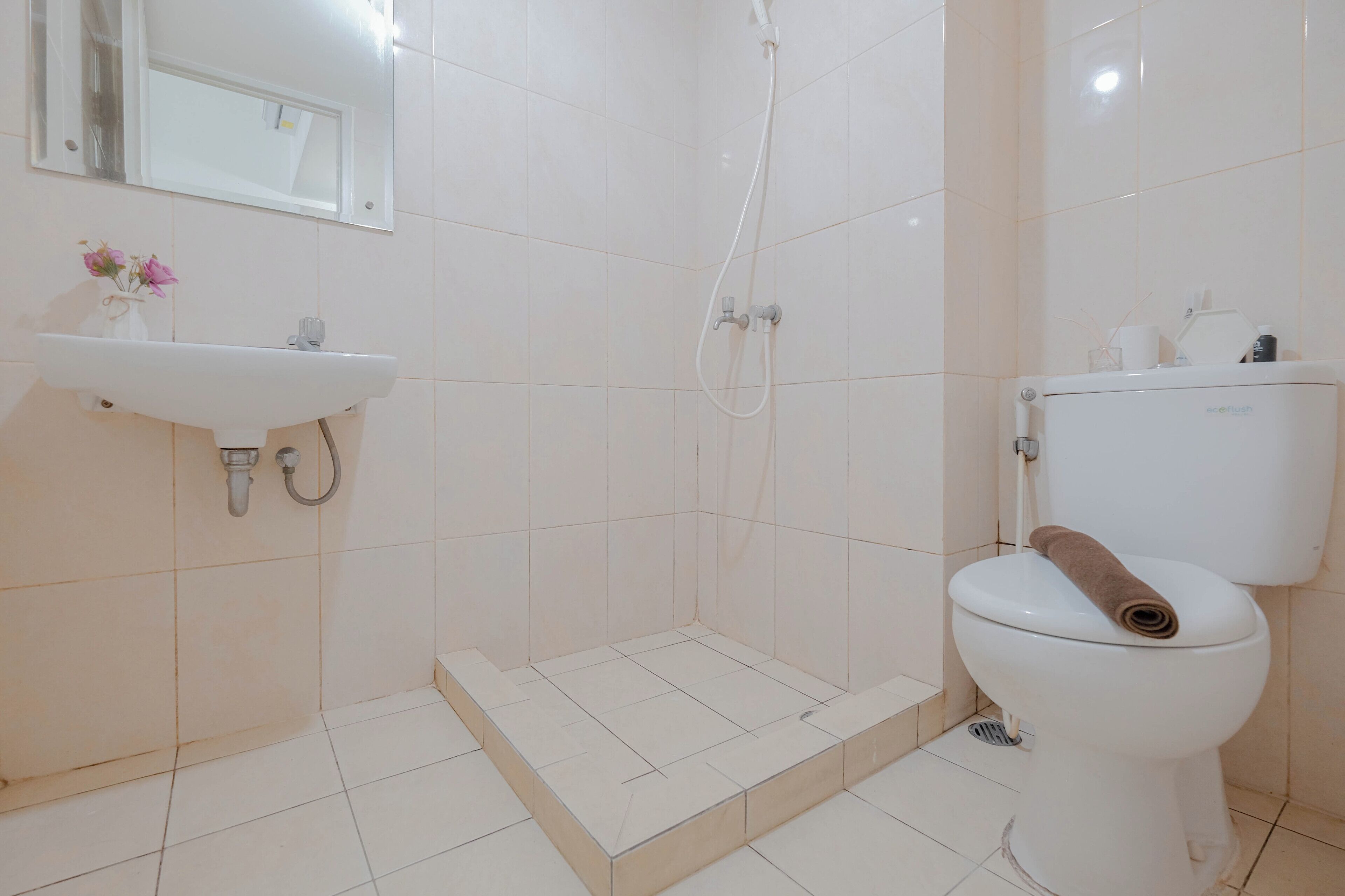 A bathroom with a white sink, toilet, and shower.