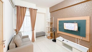 Una sala de estar moderna con un sofá, un televisor montado en un panel de madera y un ventilador.