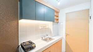 Una cocina moderna con encimeras blancas, un lavamanos integrado y armarios de madera.