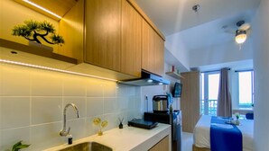 Una cocina moderna con un lavamanos de acero inoxidable, armarios de madera y una estufa empotrada.