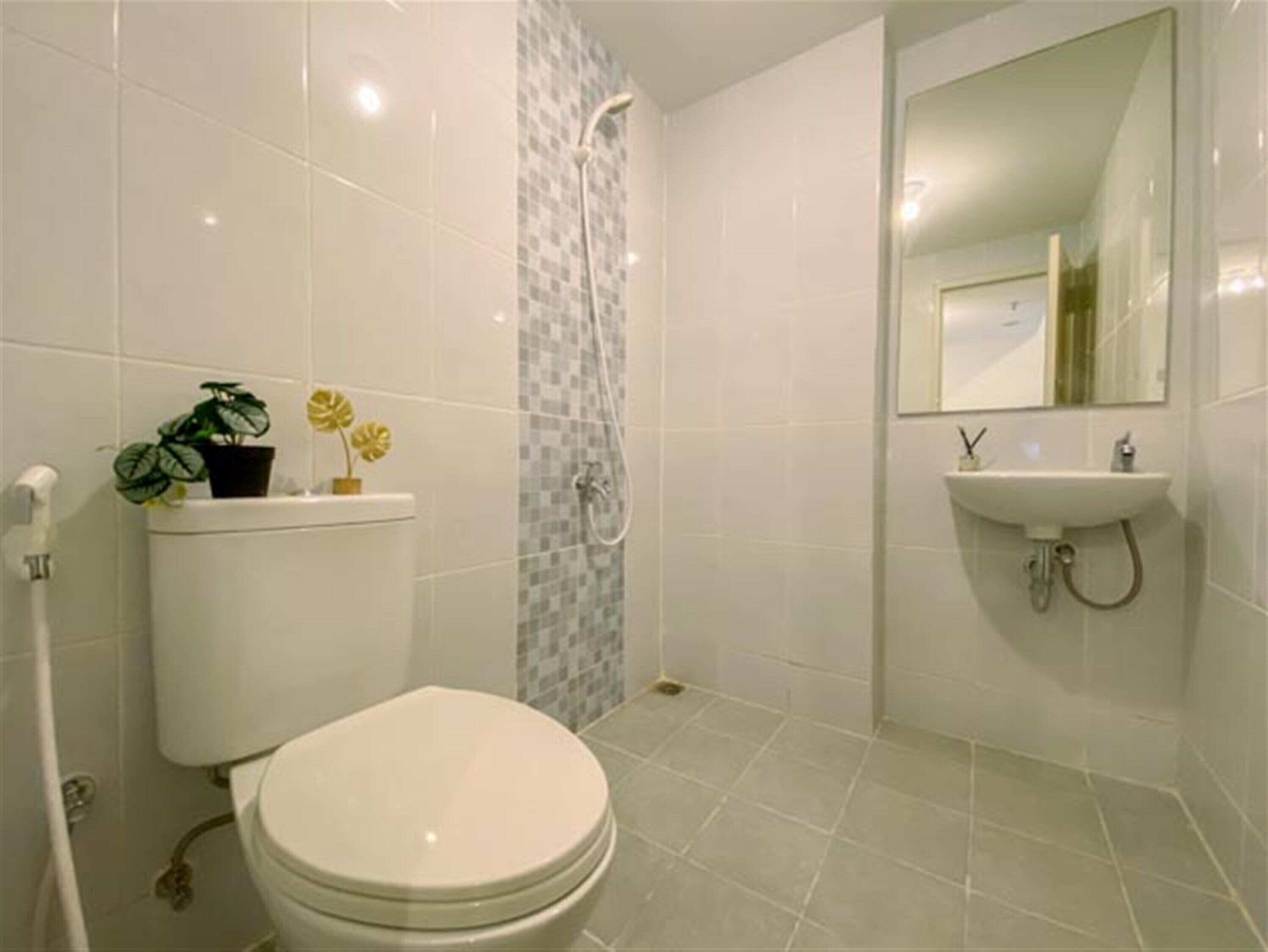 Ein Badezimmer mit Toilette, Waschbecken, Spiegel und Dusche.