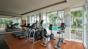 A gym with treadmills, elliptical machines, and an exercise bike. - The Urban 2BR at Vida View Makassar Apartment (Makassar)