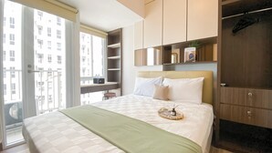 Une chambre moderne avec un grand lit, une armoire intégrée et un balcon offrant une vue sur la ville.