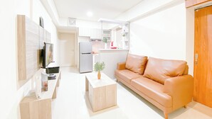Een moderne woonkamer met een leren bank, een flatscreen televisie en een houten salontafel.