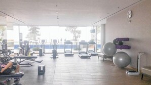 A gym with treadmills, stationary bikes, and exercise balls.