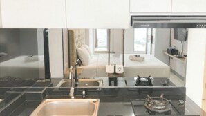 A modern kitchen with a black countertop, stainless steel sink, and a gas stove.