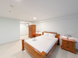 Un dormitorio con cama de madera, mesita de noche, cómoda y armario.