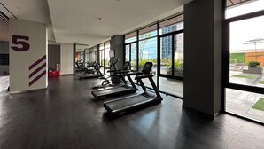 Een moderne sportschool met loopbanden en fitnessapparatuur, grote ramen en een schoon, ruim interieur.