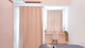 Een slaapkamer met een bed, een bureau en een stoel.