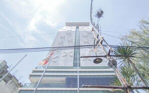 Un edificio moderno con fachada de vidrio y una bandera a la izquierda.