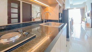 A modern kitchen with a stainless steel sink, granite countertop, and overhead lighting.