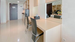 A modern kitchen with a dining area, featuring a kitchen island, chairs, and a large mirror.
