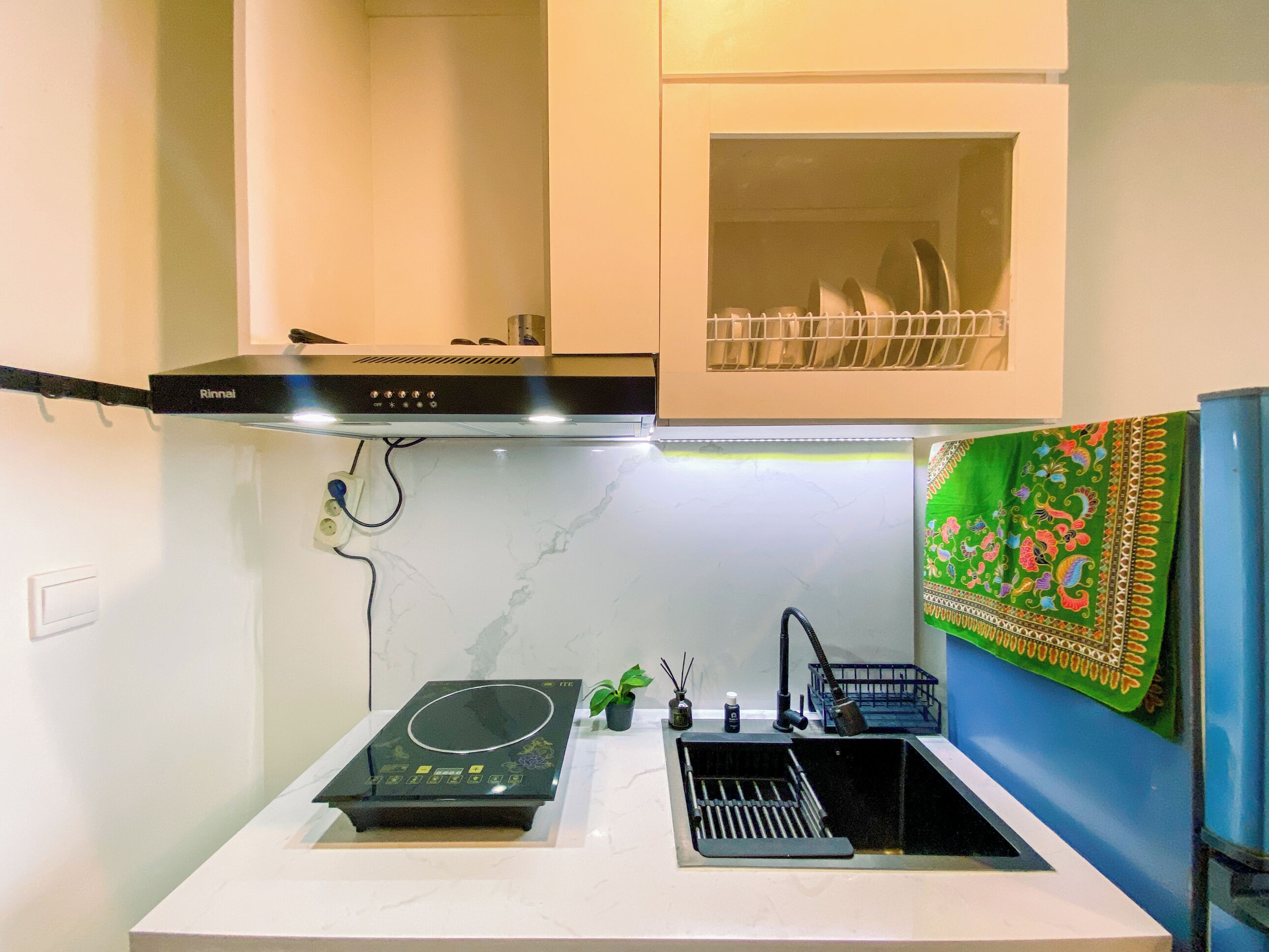 A compact kitchen with a built-in induction cooktop, a sink, and a small countertop area.