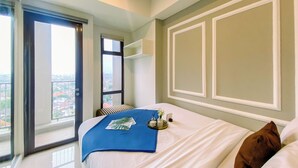 Ett hotellrum med en stor säng, utsikt genom ett fönster och en balkong.