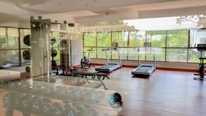 A gym with treadmills, weight machines, and a mirrored wall.