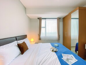 Relax in a cozy retreat with a neatly made bed, a wooden wardrobe, and a bedside table.
