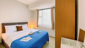 A hotel room with a bed, a bedside table with a lamp, a window with curtains, and a wooden wardrobe. - Best and Cozy 2BR Apartment Royal Olive Residence (Jakarta)