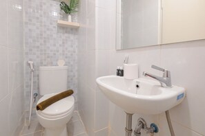 Une salle de bain avec des toilettes, un lavabo et un miroir.