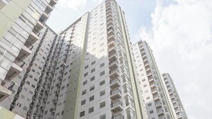 A high-rise residential building with multiple balconies and a modern architectural design. - The Spacious 2BR at Grand Asia Afrika Apartment (Bandung)