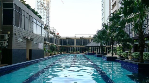 A swimming pool with a view of a building labeled "SPOET" in the background. - Comfortable and Simply 1BR Apartment Centro City (Jakarta)