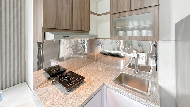 Une cuisine moderne avec des meubles en bois, des appareils en acier inoxydable et un plan de travail en granit.