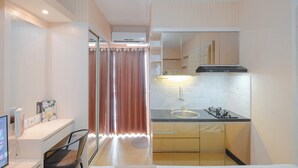 Una cocina moderna con estufa a gas, lavamanos y espejo sobre la encimera.