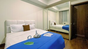 A hotel room with a bed, a mirror, and a door. - Spacious and Cozy 2BR Apartment Kemang Village (Jakarta)