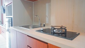 Een moderne keuken met een dubbele spoelbak, een inbouwfornuis en houten kastjes.