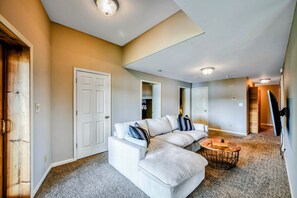 A spacious living room with a sectional sofa, a coffee table, and a carpeted floor. - Lakefront Lake Anna Log Cabin, Views, Dock, Deck (Bumpass)