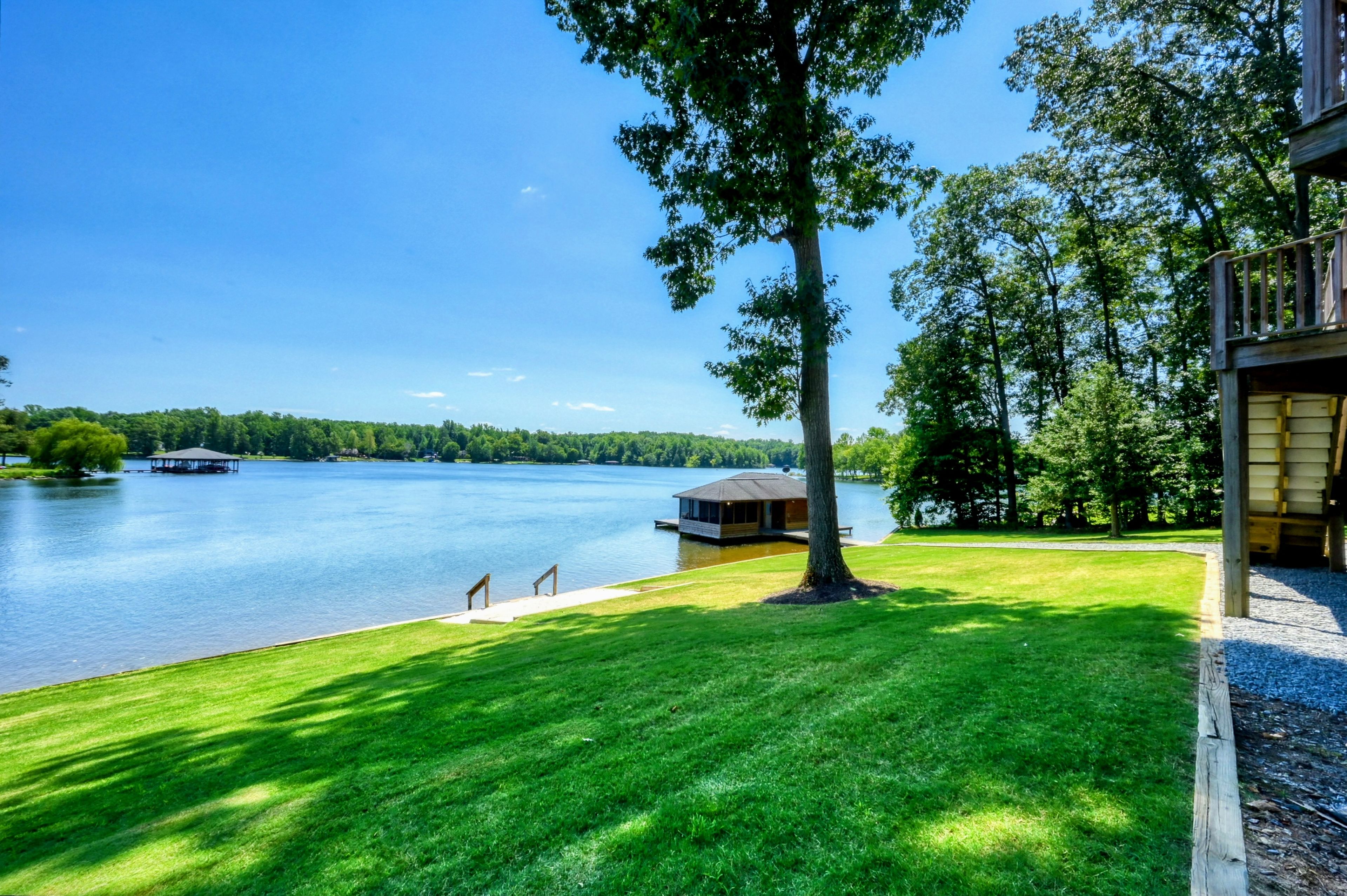 Une propriété au bord du lac, dotée d’un quai, d’un petit bâtiment et d’une pelouse bien entretenue.