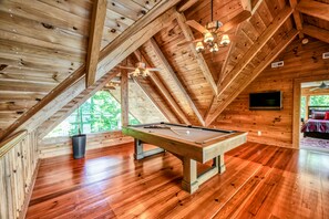 A wooden interior with a pool table, wooden beams, and a ceiling fan. - Lakefront Lake Anna Log Cabin, Views, Dock, Deck (Bumpass)