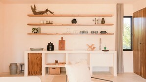 A modern, minimalist room with a white sofa, a wooden console table with shelves, and a large window with curtains. - Chic Beach suite with Plunge Pool in Tulum Hotel Zone (Tulum)