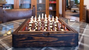A chessboard on a checkered table in a room with wooden furniture and a view of a living area. - Matilda - Stunning, 3-bed, vintage home in Duluth! (Duluth)