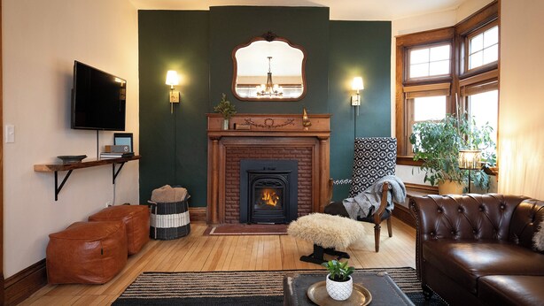 A living room with a fireplace, a television, and a comfortable seating area. - Matilda - Stunning, 3-bed, vintage home in Duluth! (Duluth)