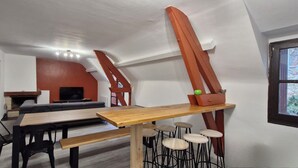 Un intérieur moderne comprenant un coin repas, des tabourets de bar et une cheminée.