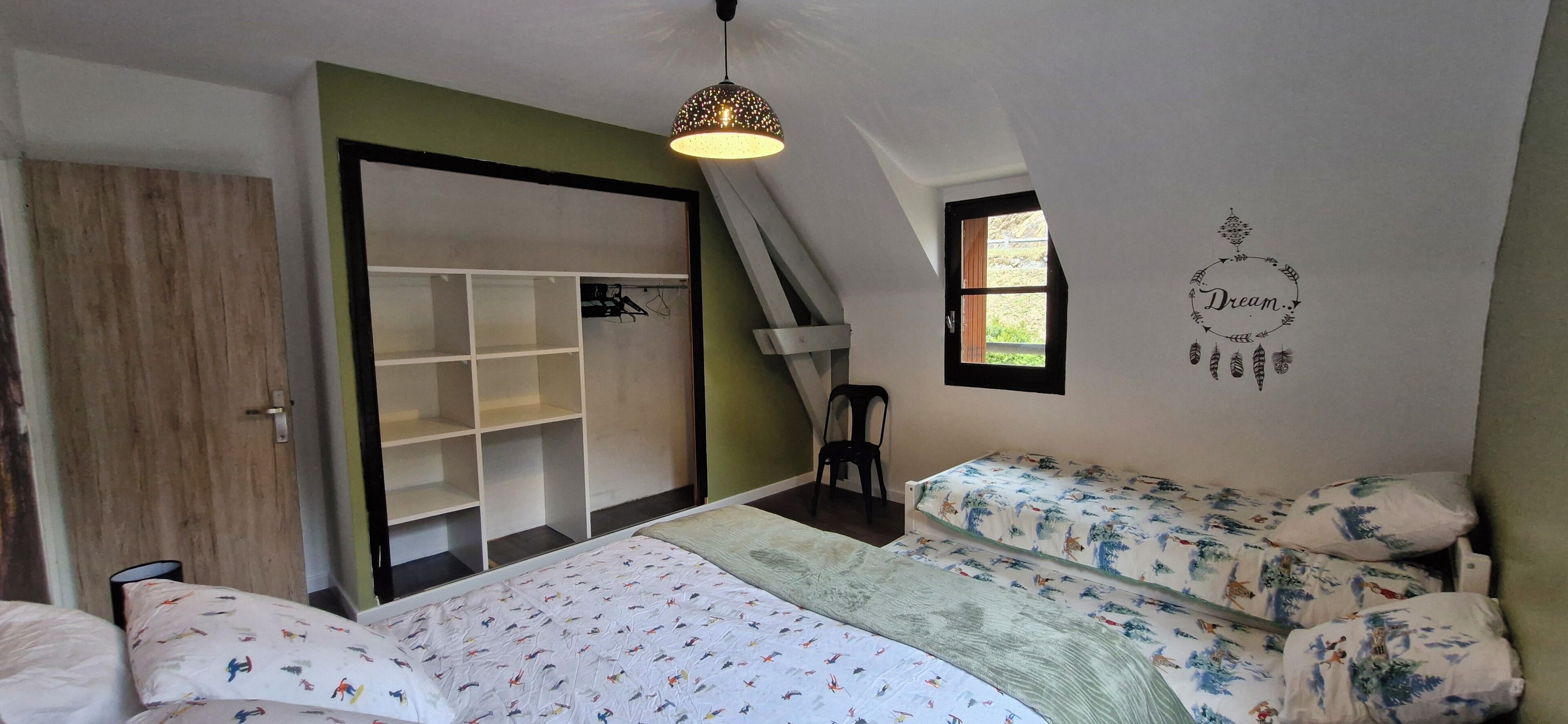 Ein Schlafzimmer mit einem Bett, zwei Nachttischen, einem Kleiderschrank, einem Fenster und einer Wanddekoration.