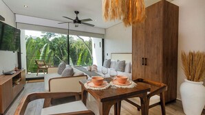 Uma sala de estar moderna com um sofá, uma mesa de jantar com tigelas laranja e um armário de madeira grande.