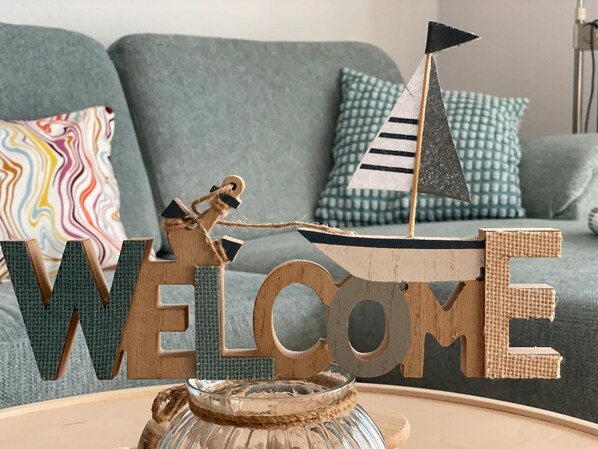 A wooden sign with the word "WELCOME" and a sailboat decoration. - Ferienwohnung Strandhupfer auf der Insel Fehmarn (Fehmarn)