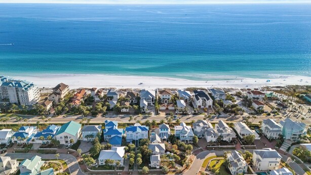 Une zone résidentielle côtière comprenant des propriétés en bord de mer, une route et une plage.