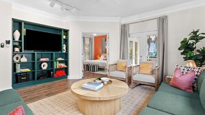Un salon comprenant un téléviseur, des étagères à livres, un canapé et une table basse.