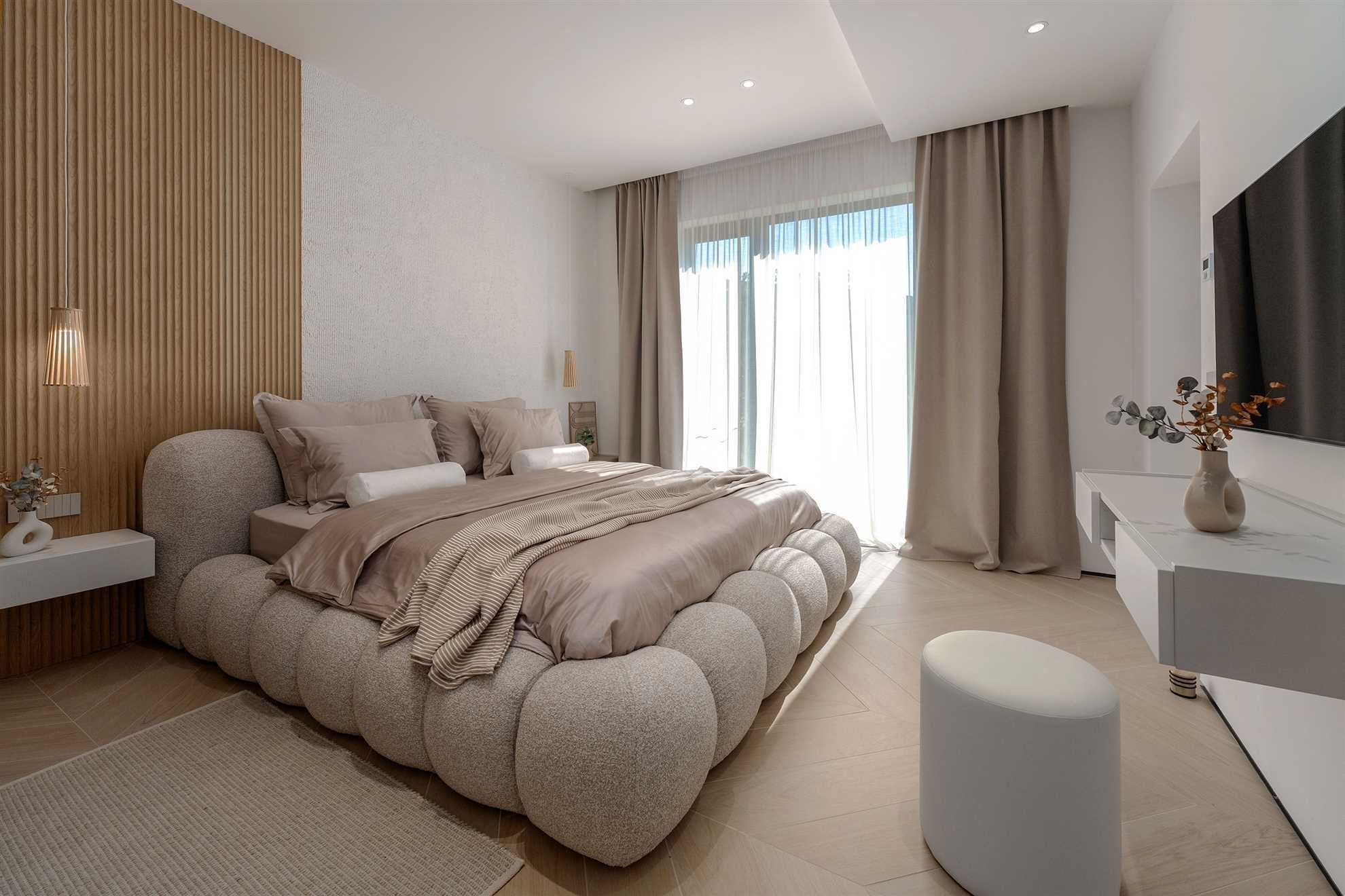 A modern bedroom with a large bed, bedside tables, a bedside lamp, a mirror, and a window with curtains.