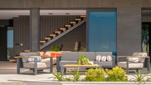 A modern living area with a sofa set, coffee table, and plants.