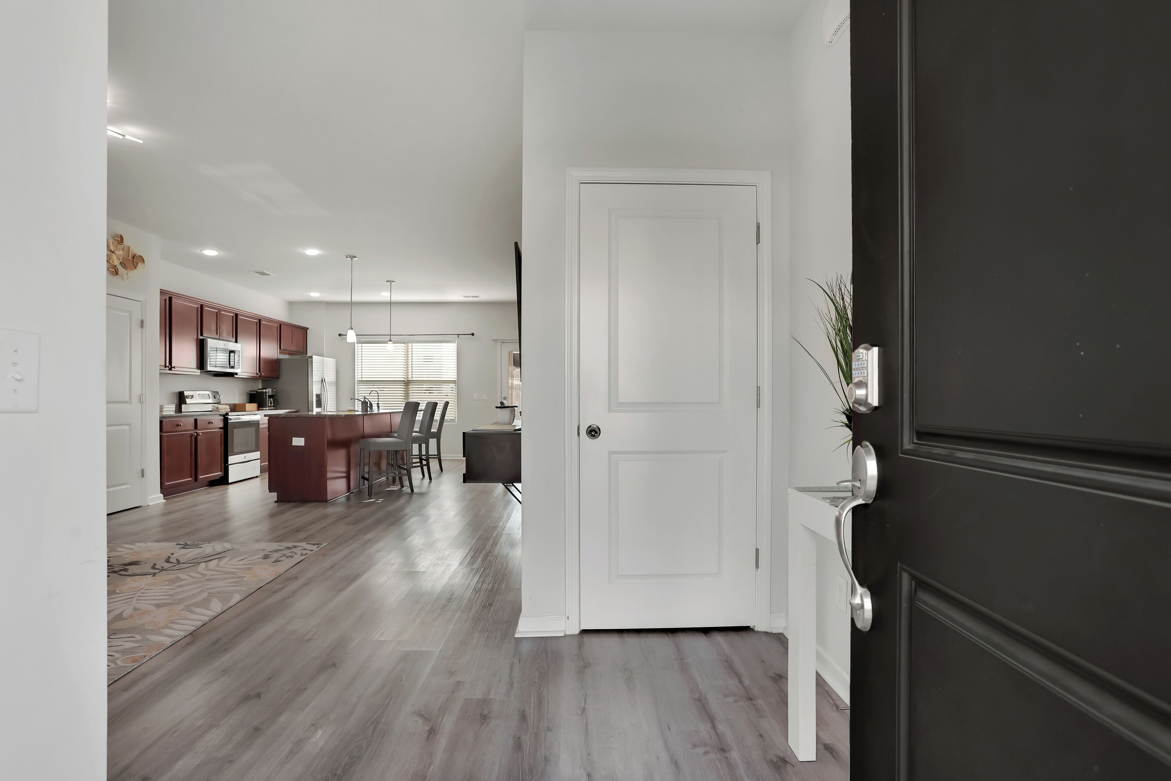 A modern kitchen with wooden cabinets, a central island, and pendant lighting.